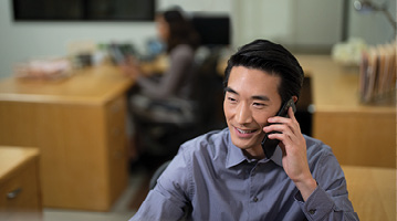 man sitting at a desk and talking on the phone